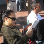 Waiting for the parade and reading a VSK from pre-parade leafleting by Ann, Katherine, Mila, Reeba and Tammy