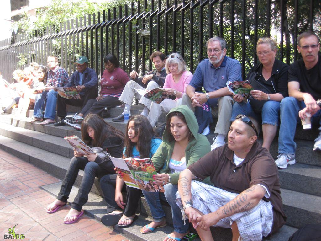 Waiting for the parade and reading a VSK from pre-parade leafleting by Ann, Katherine, Mila, Reeba and Tammy